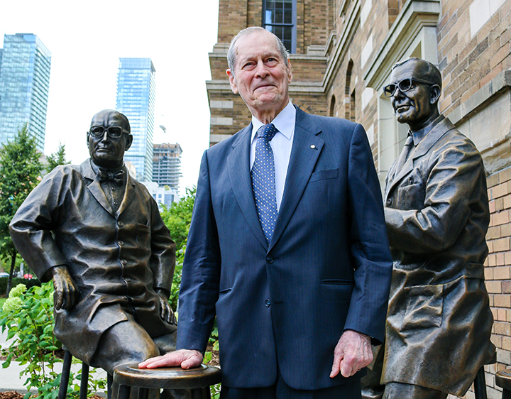 Photo of James Till with a new permanent sculpture depicting him and Ernest McCulloch, who proved the existence of stem cells in the 1960s.